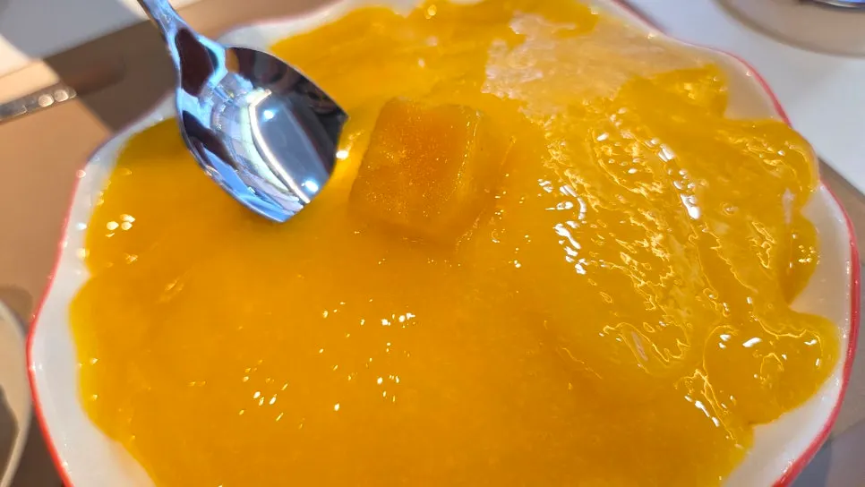 A spoonful of ice scooped from the apple mango bingsu