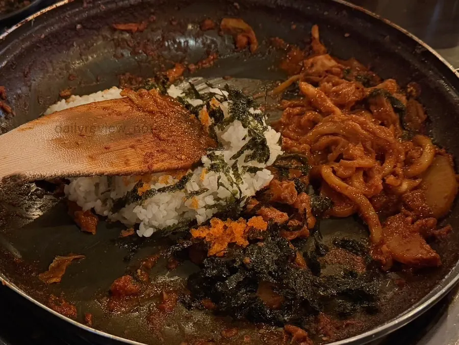 Rice, seaweed flakes and flying fish roe being stir-fried together