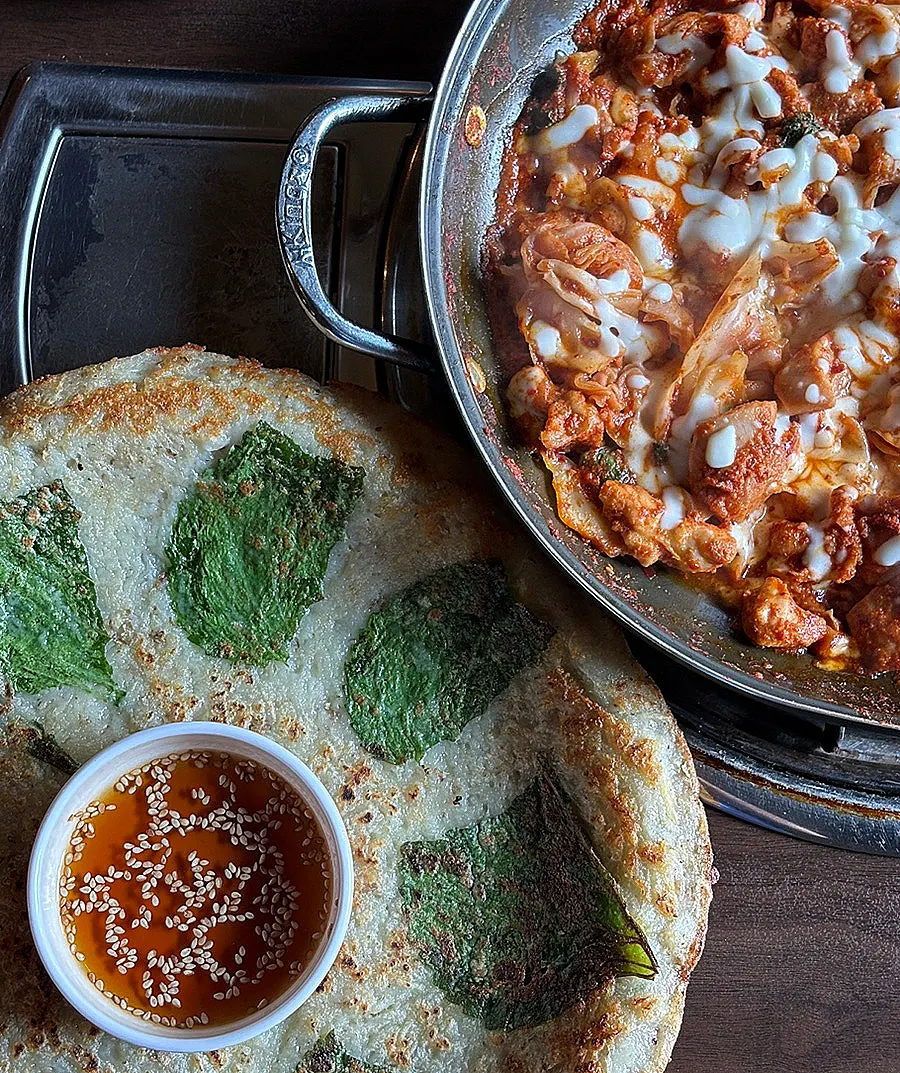 A spread of potato pancake and cheese dakgalbi