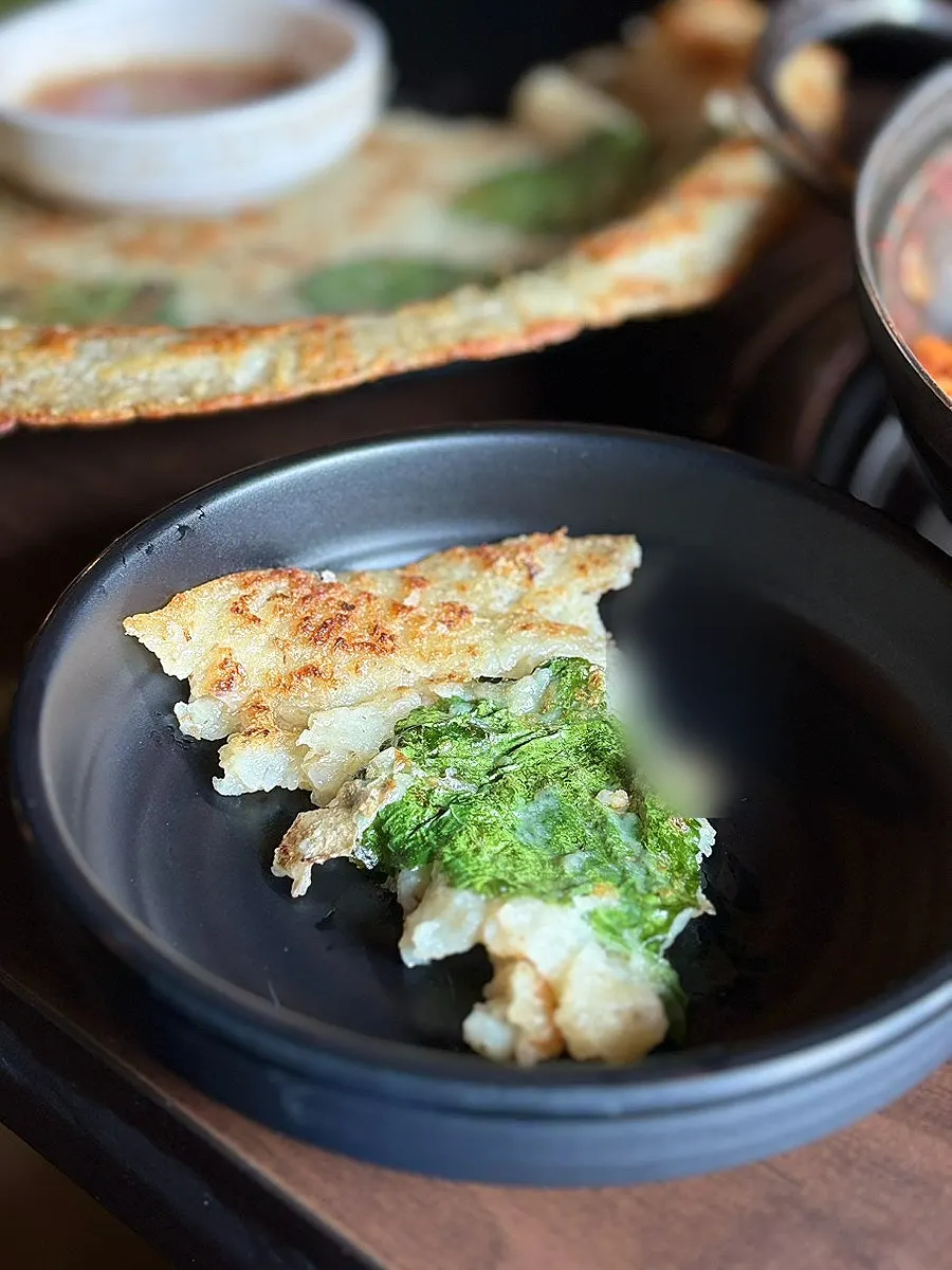 Cheese dakgalbi piled onto potato pancake for a wrap