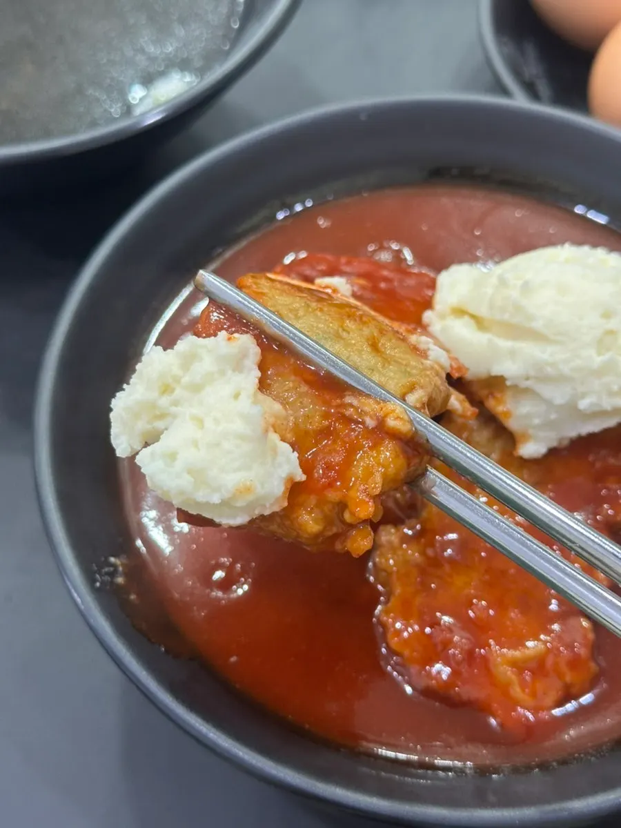 A thick garaetteok piece picked up with chopsticks