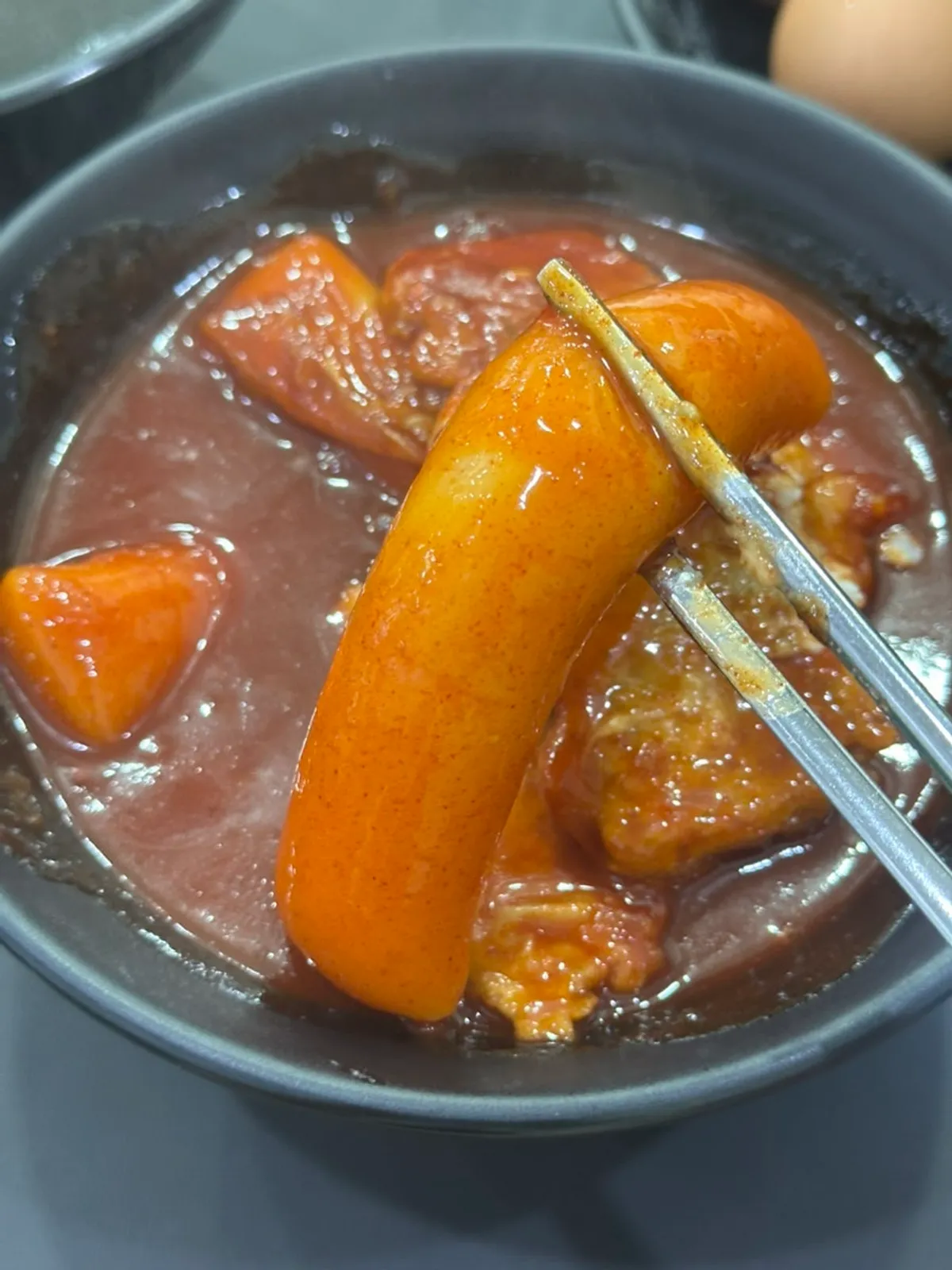 A bite of garaetteok topped with potato salad