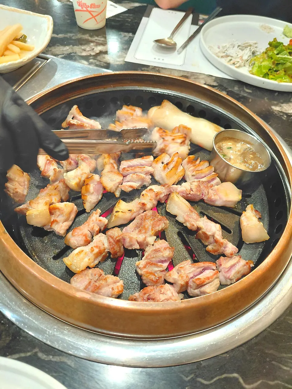 Thick, scored black pork grilling on the pan
