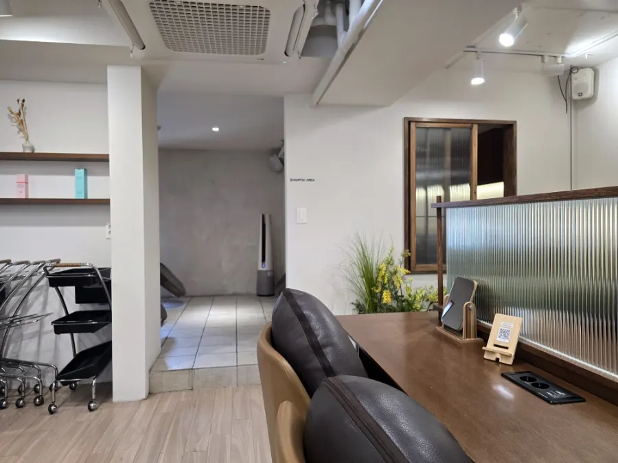 Bright salon interior with large windows and wood-toned furniture