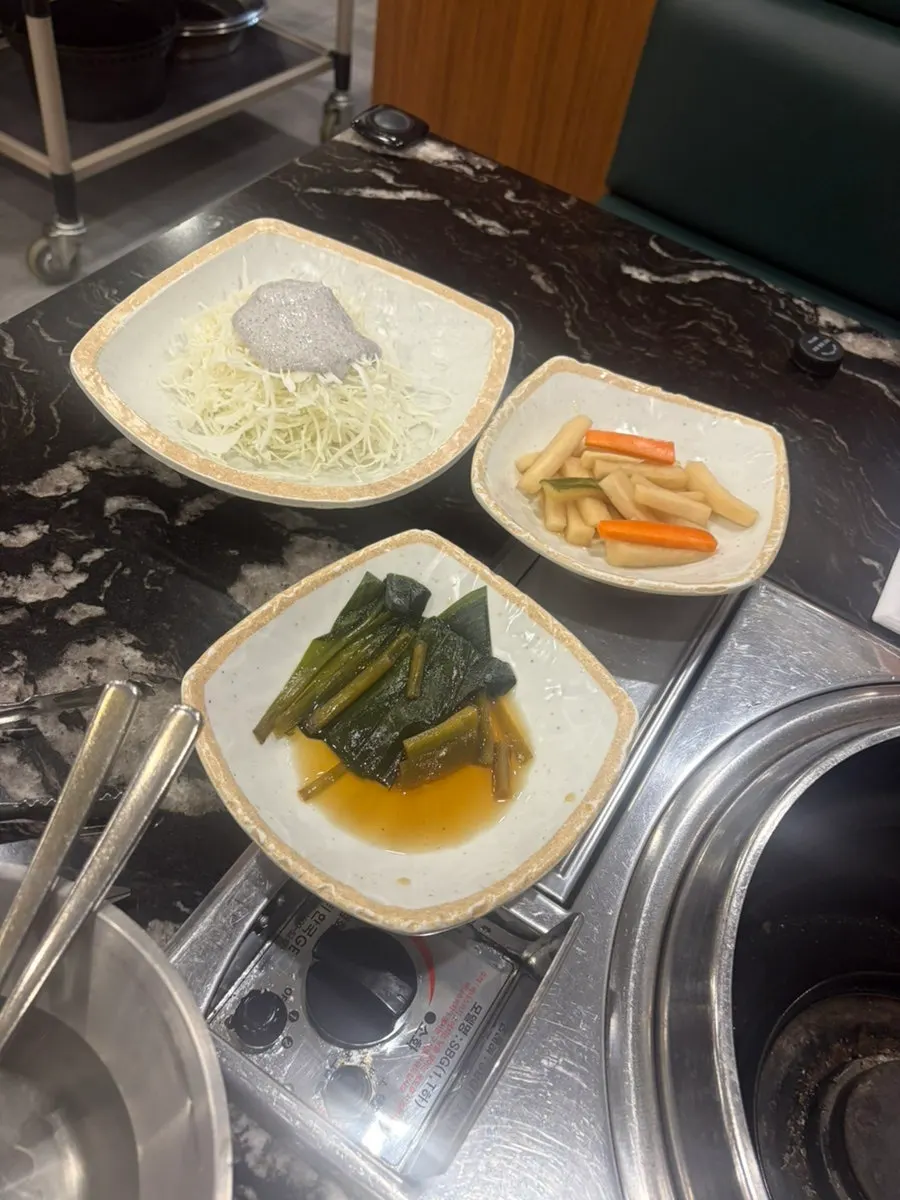 Complimentary lettuce salad, green onion kimchi, and white kimchi