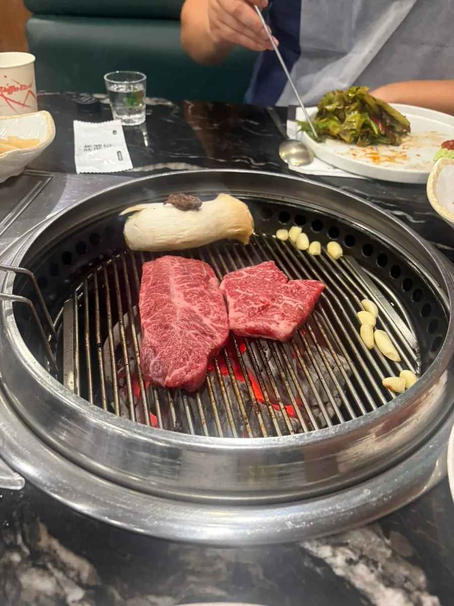 Hanwoo sirloin grilled and served by a staff member