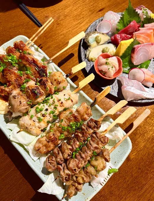 Table set with sashimi, yakitori and tokkuri