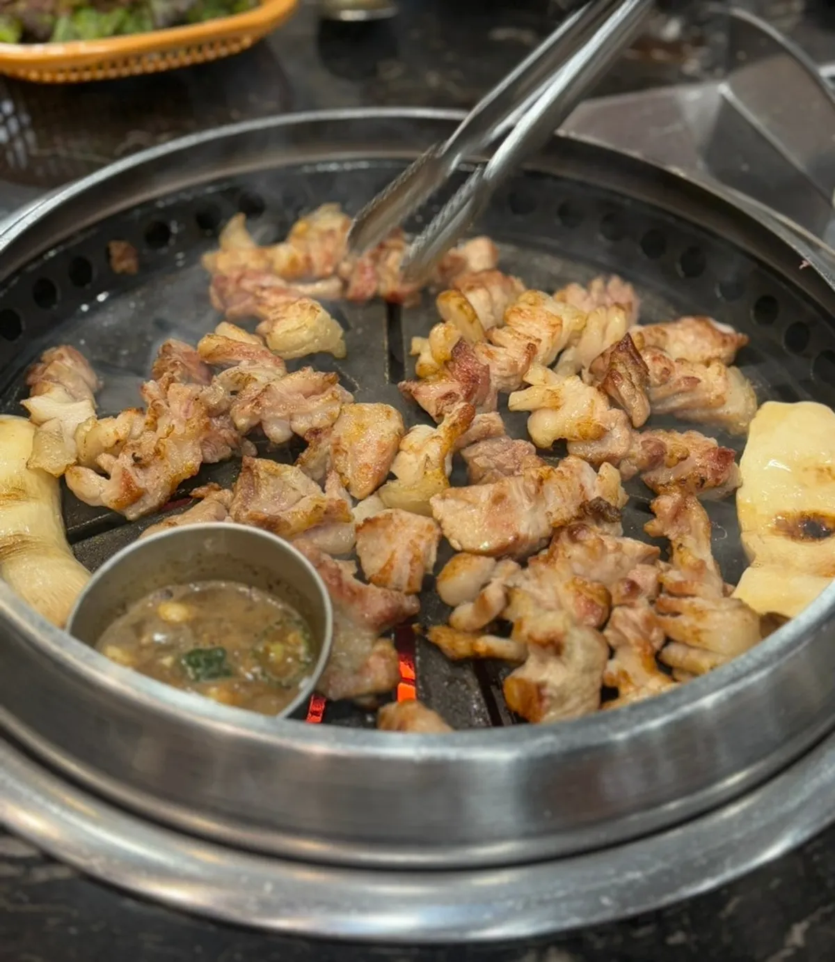 칼집 낸 오겹살이 숯불 불판에 익는 모습