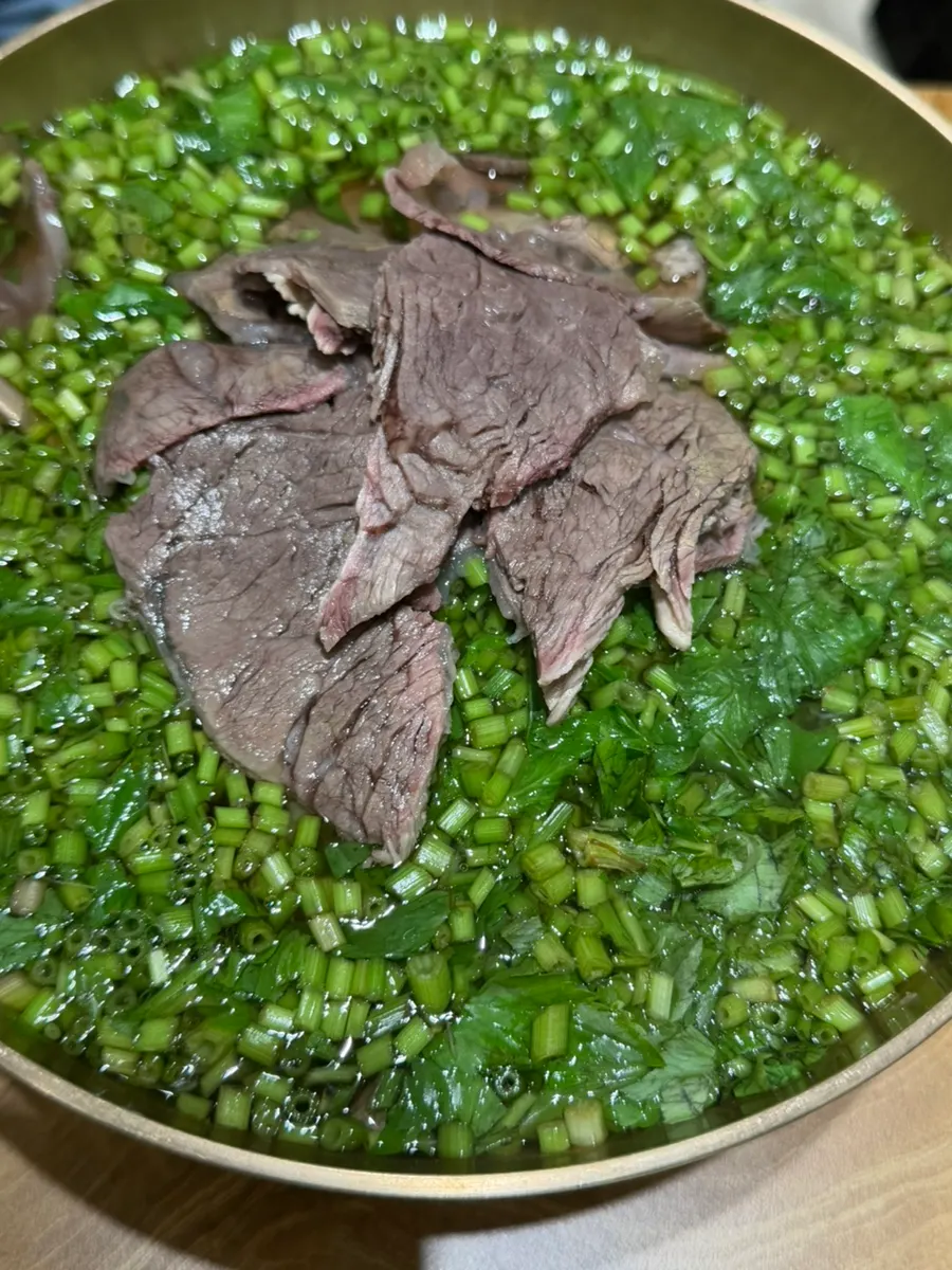 Clear gomtang topped with minari