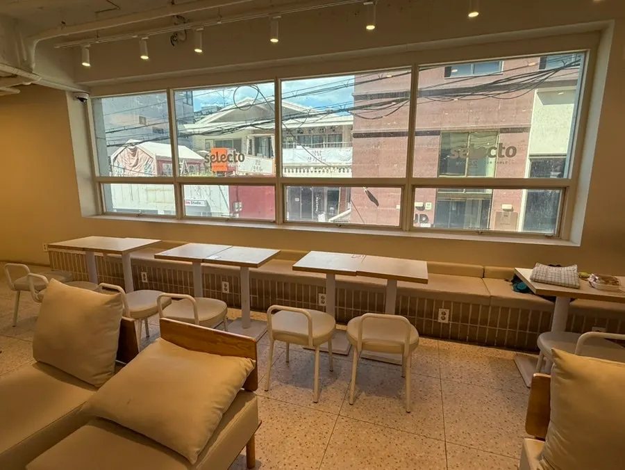Café seating running alongside the floor-to-ceiling windows