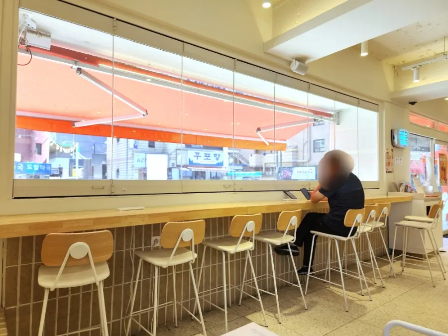 Café table seat with a cushioned backrest