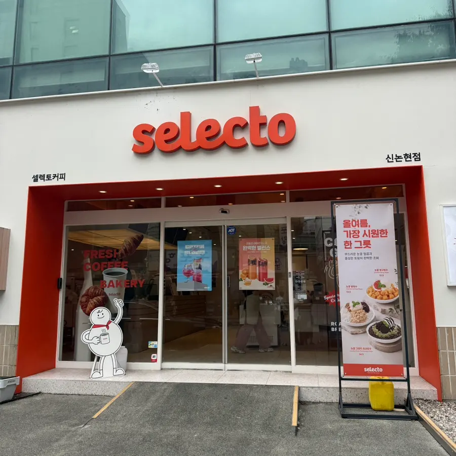 골목 좌측에 보이는 셀렉토커피 신논현점 외관과 야외 테라스