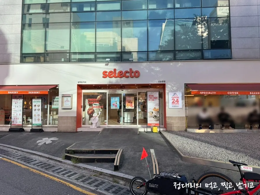 White signboard with orange 'selecto' lettering