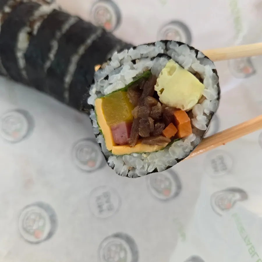 Cheese gimbap dipped in tteokbokki sauce