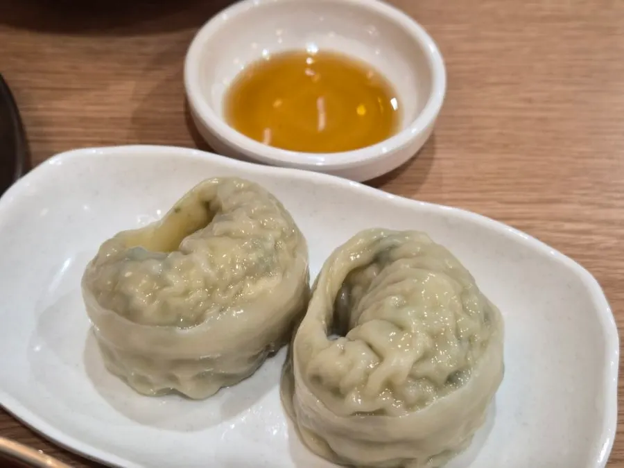 A dumpling cut in half revealing the meat filling