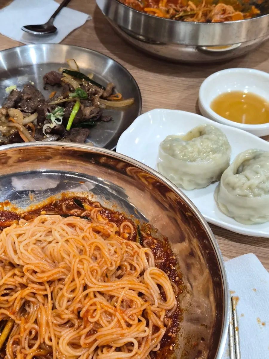 Full spread of bibim milmyeon, dumplings, and soy bulgogi