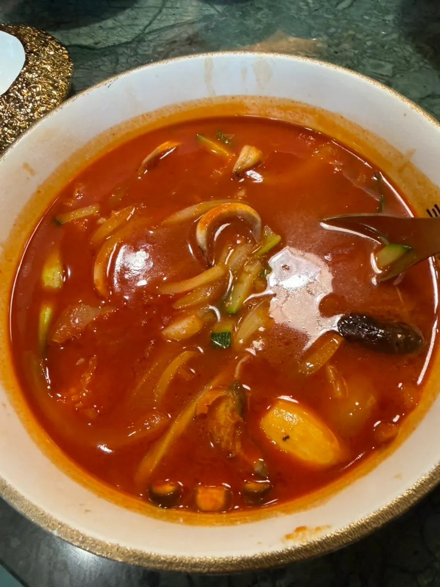 Bowl of jjamppong loaded with onion and zucchini