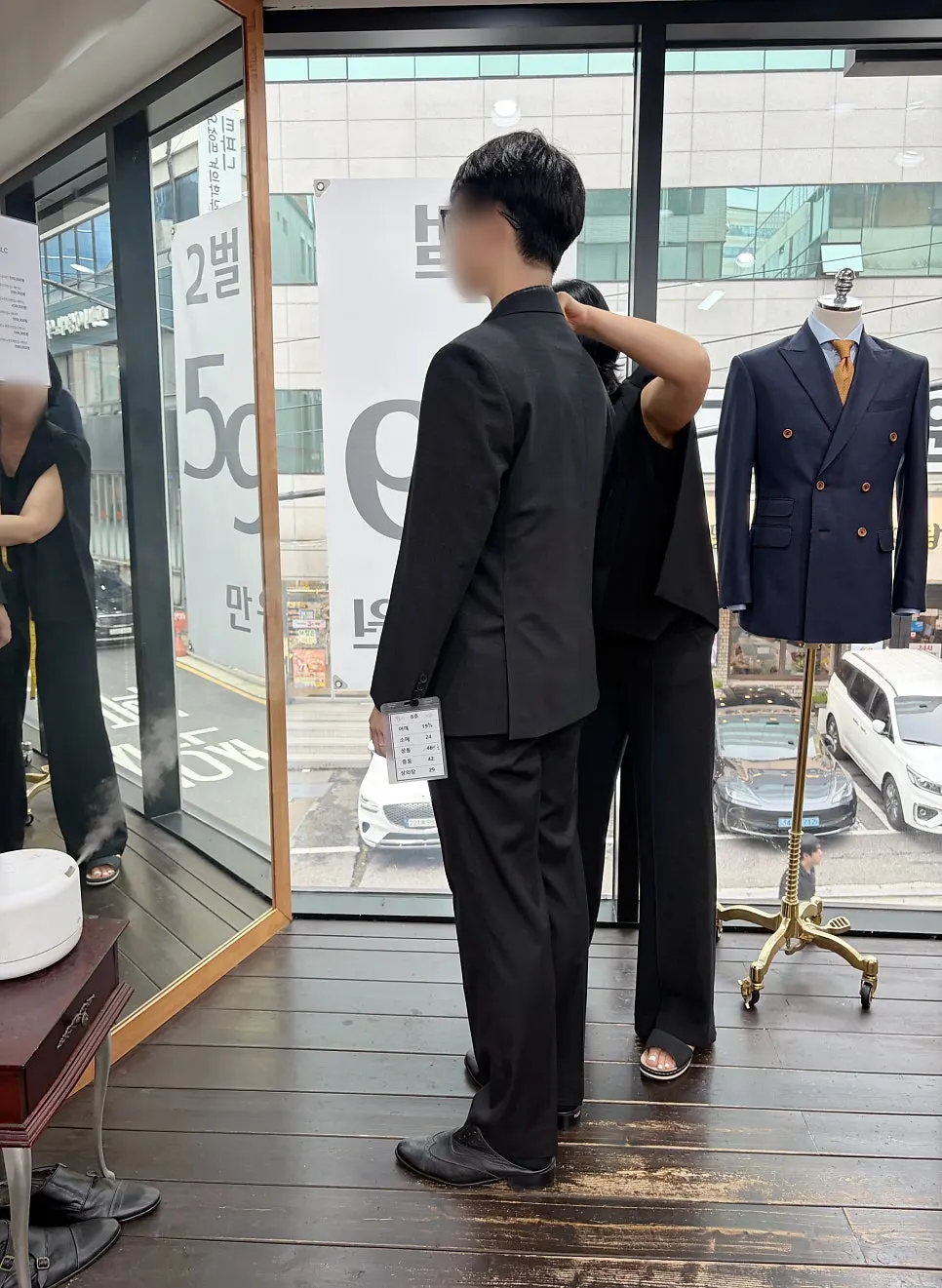 Scene of custom suit measurements being taken