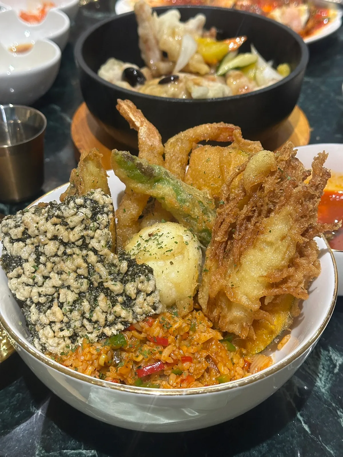 Vertical shot of kimchi fried rice topped with tenpura