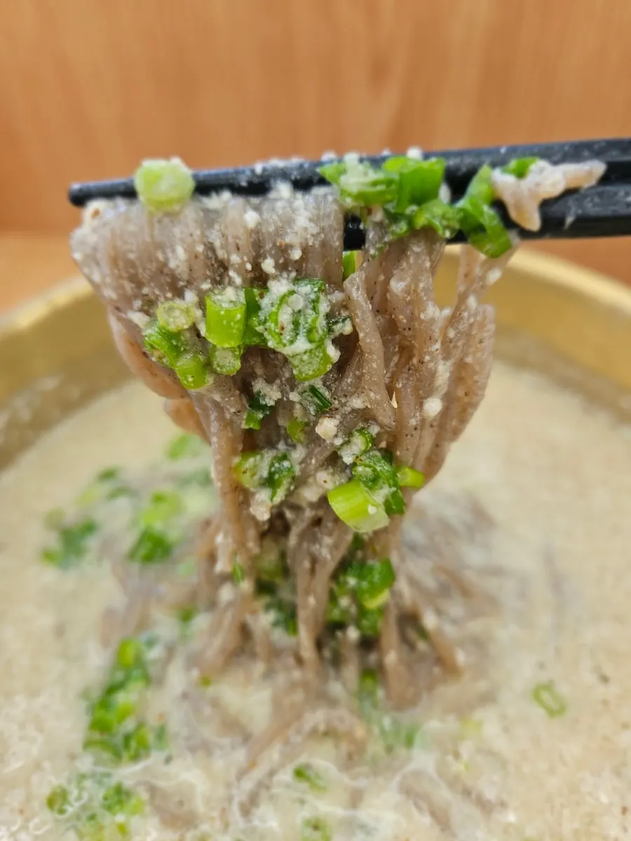 Scooping up the perilla hot noodle broth
