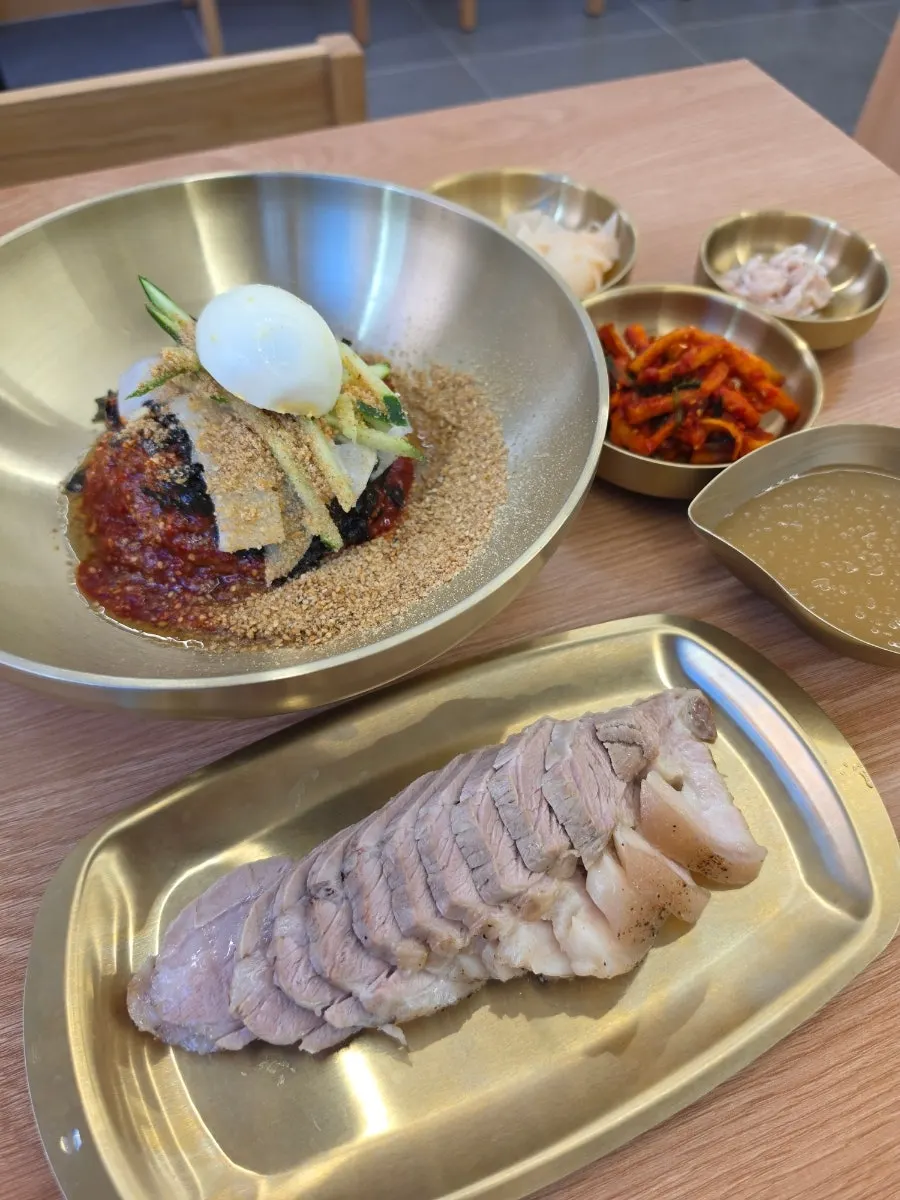 A solo lunch spread with bibim makguksu and pork belly suyuk