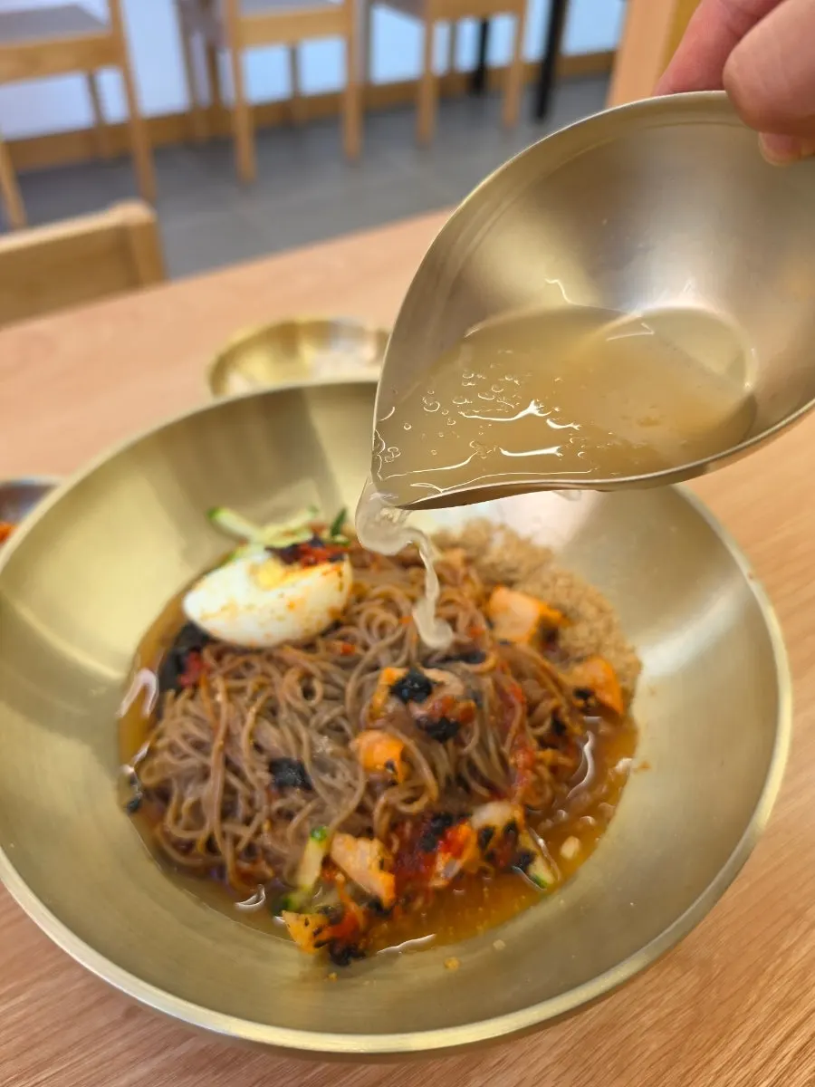 Makguksu noodles lifted with chopsticks