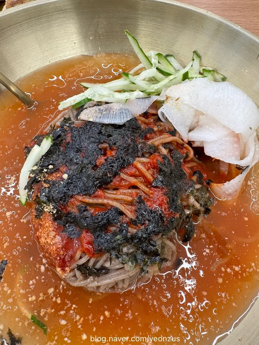 Mul makguksu with sauce sitting atop the noodles