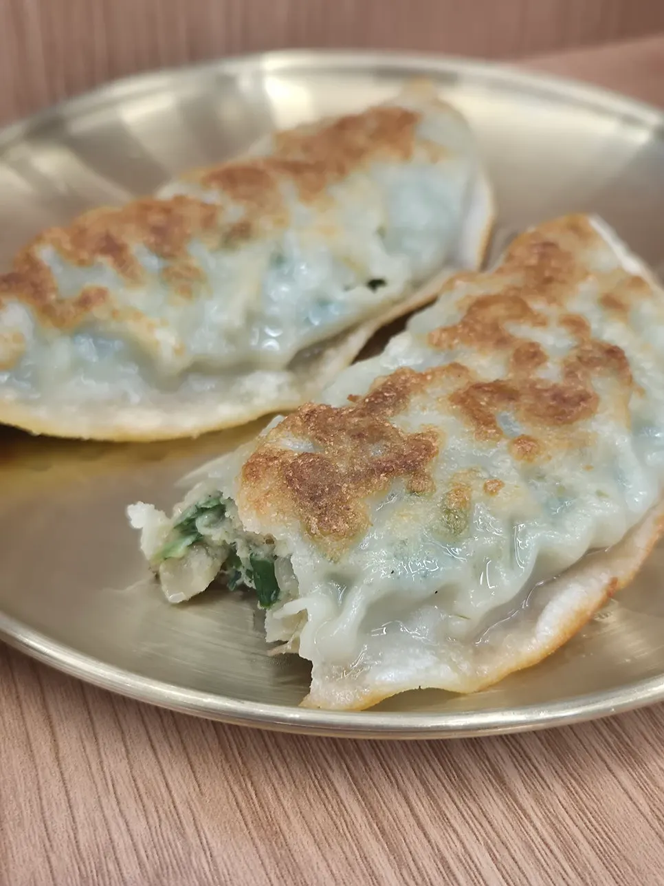 Fried mandu served with a small dish of soy sauce