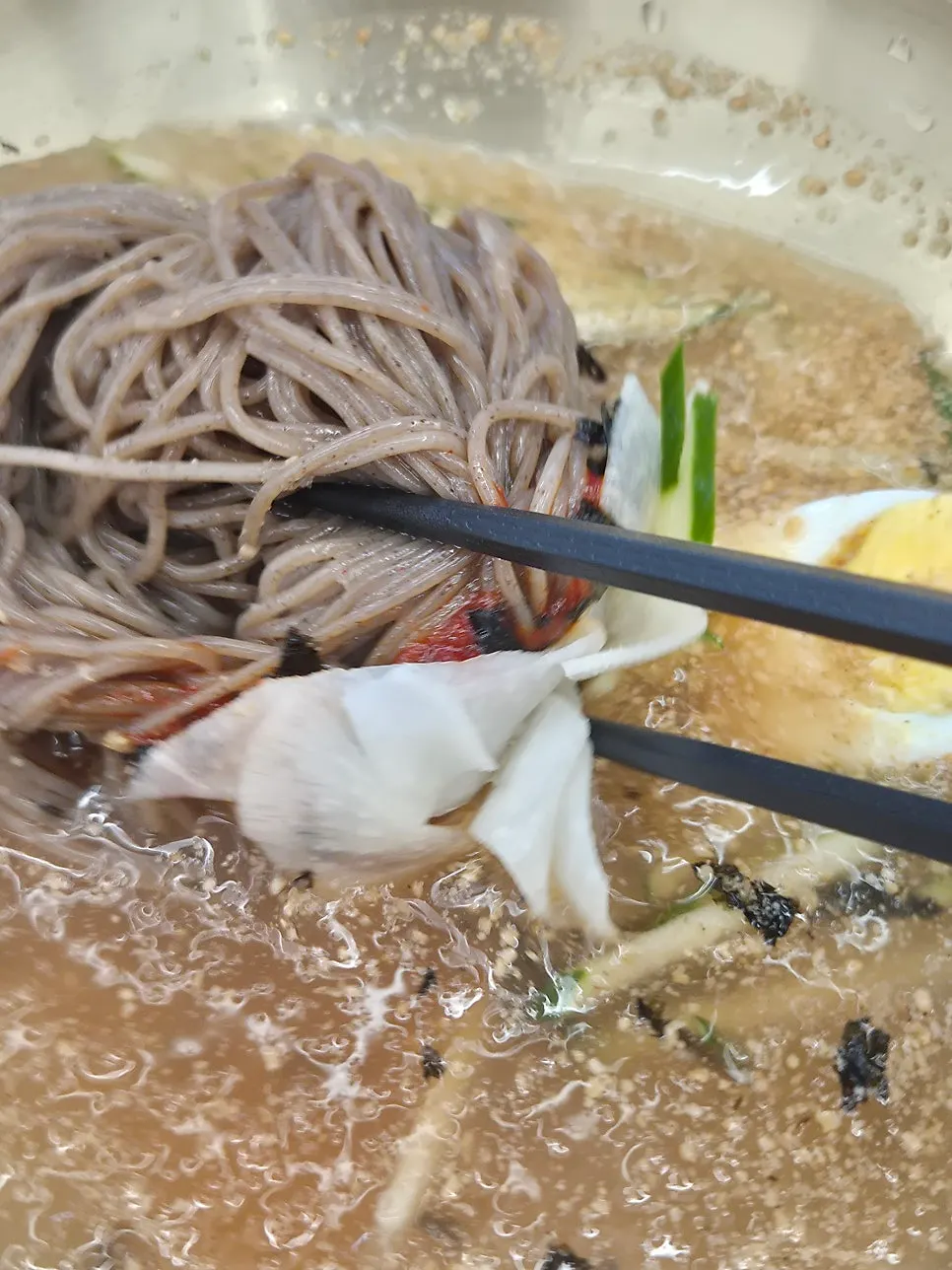 Broth with dadegi chili paste mixed into the spicy mul-makguksu