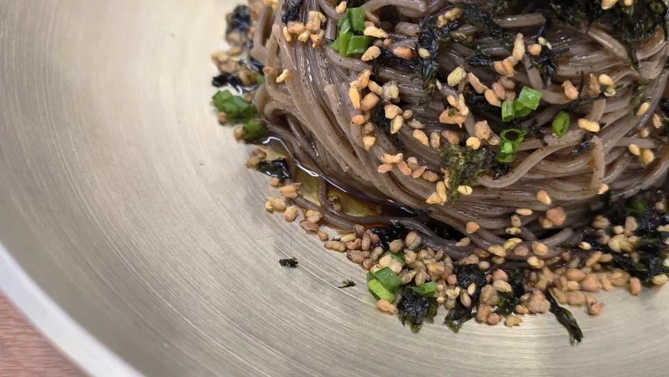 Close-up of seaweed and sesame seeds on perilla oil makguksu noodles