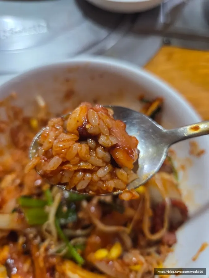 A spoonful of nakji-deopbap mixed with sesame oil