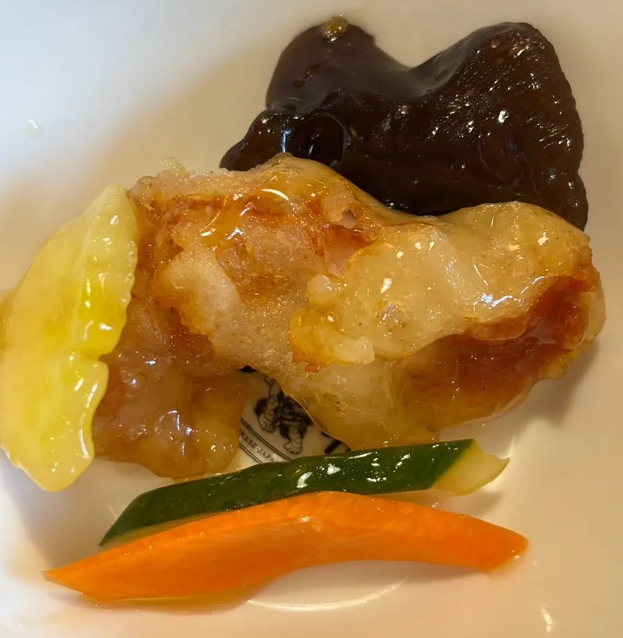 Tangsuyuk steaming beneath warm sauce