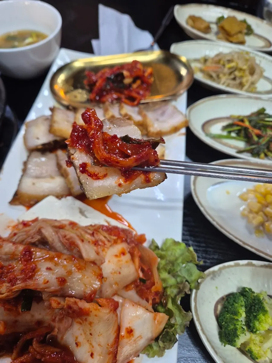 A wrap loaded with bossam and side dishes