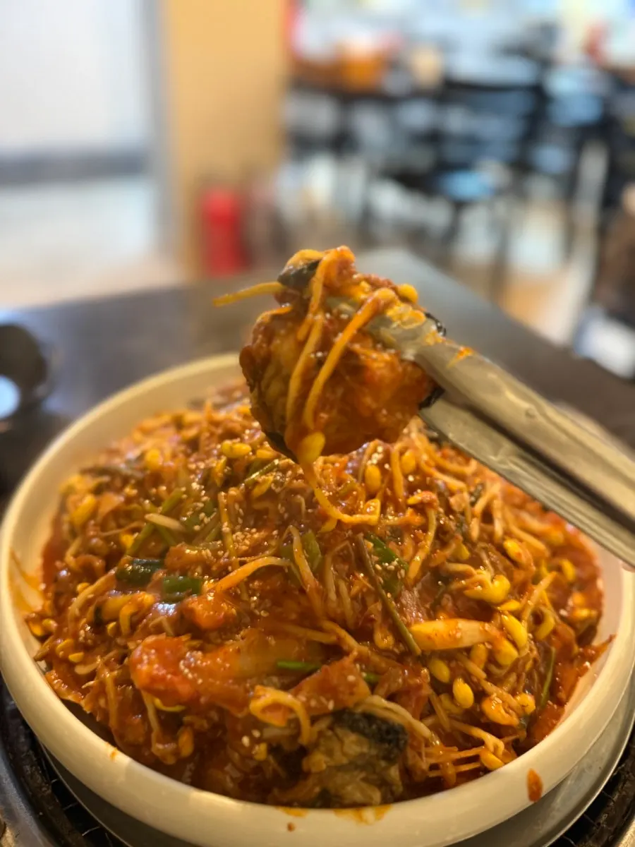 Close-up of sauced monkfish meat and bean sprouts
