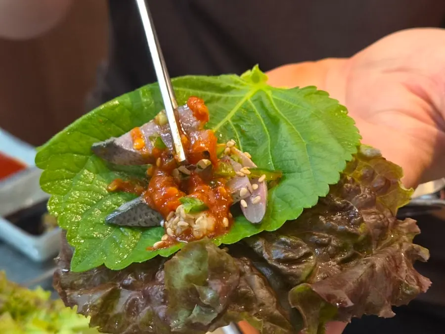 Gizzard shad sashimi wrapped in perilla leaf and lettuce with chili paste