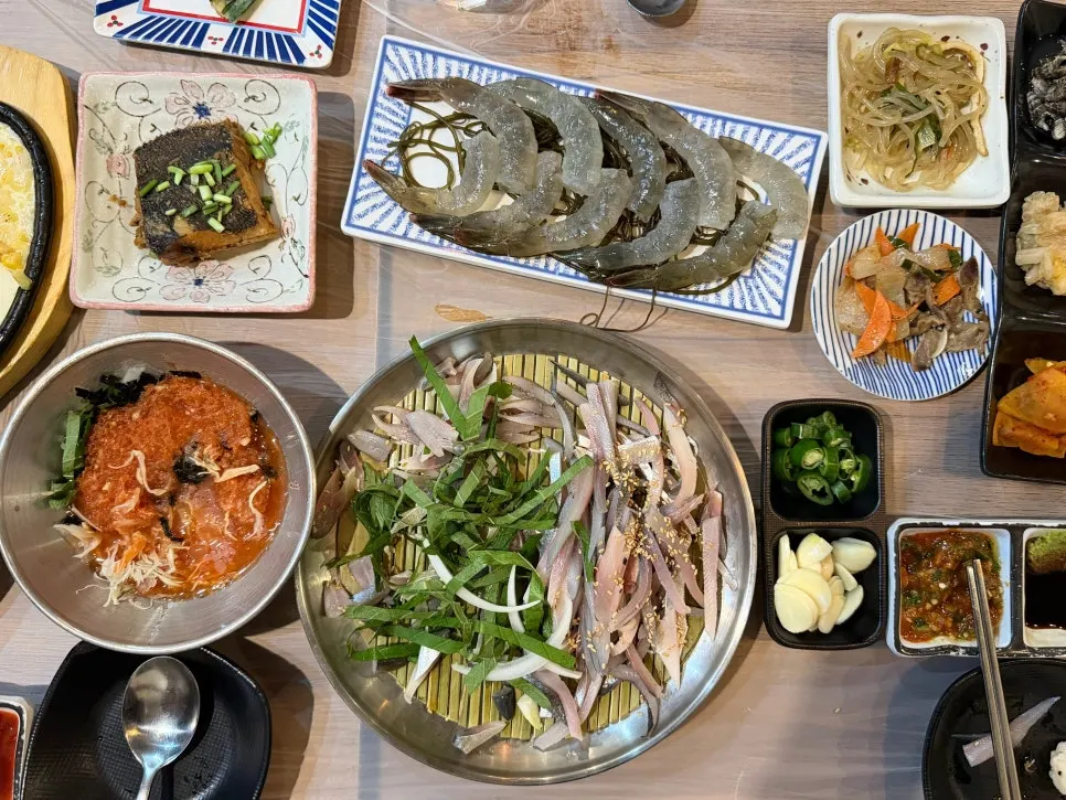 Closing table spread filled with gizzard shad sashimi and raw shrimp