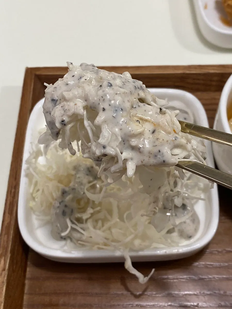 흑임자 소스를 뿌린 채썬 양배추