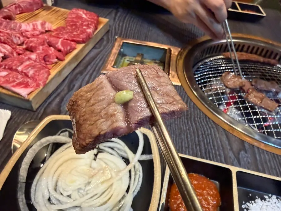 Hanwoo and tongs on the grill plate