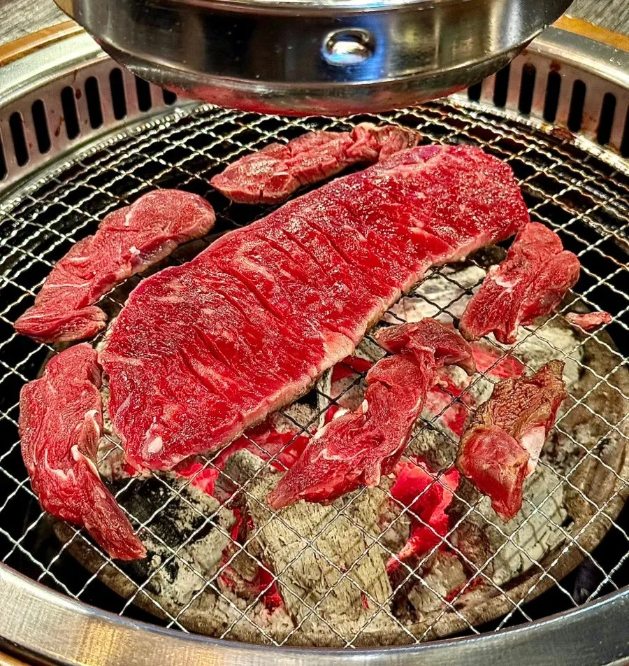 Table spread of grilled hanwoo special cuts including flap meat, chuck flap tail, and top blade