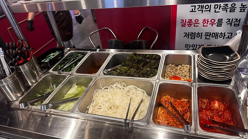 Self-serve side dish bar stocked with lettuce and pickles