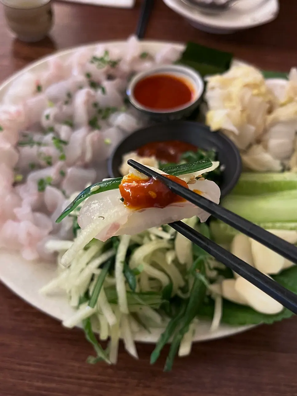 Makhoe spread served with white kimchi, kelp, and cucumber muchim
