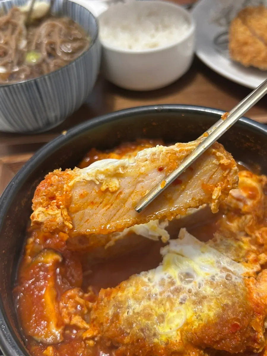 Thick piece of tonkatsu inside the kimchi nabe