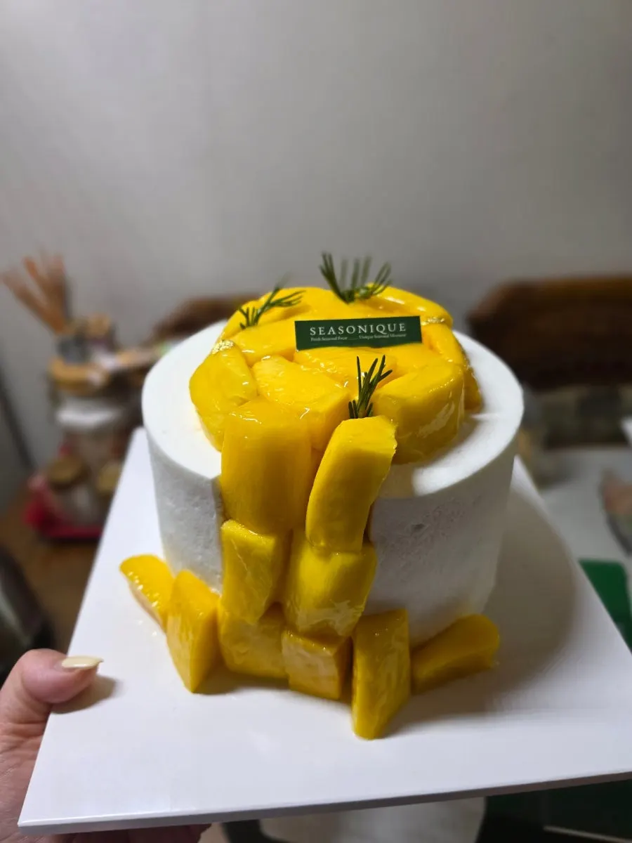 Vertical shot of whole mangoes stacked like stairs on the cake