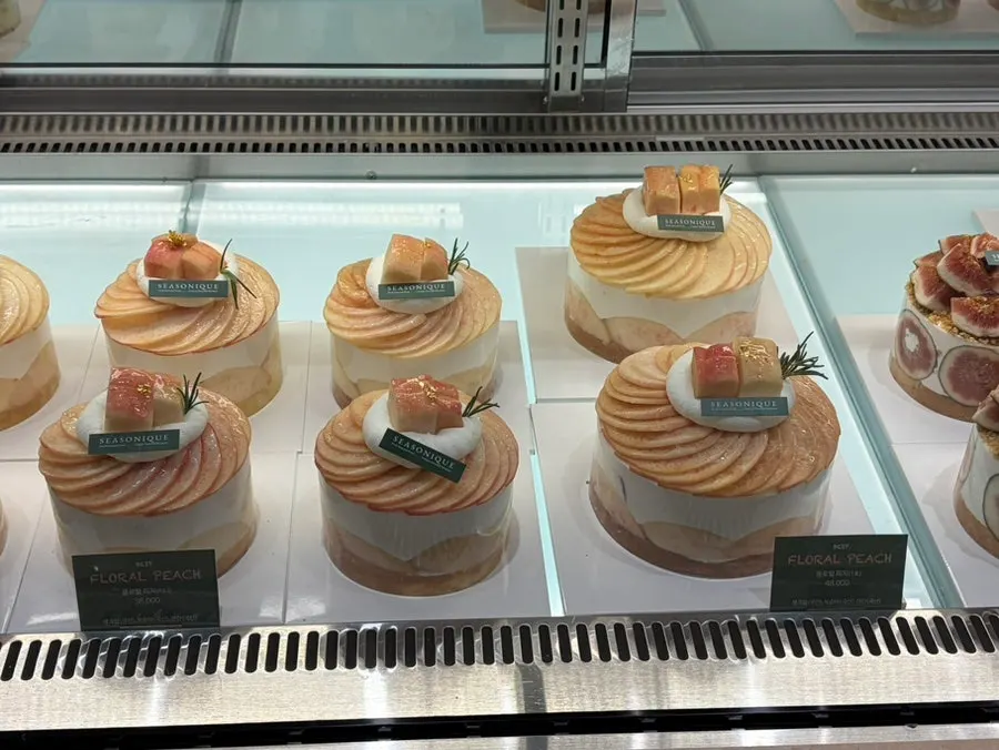 Side view of a cake topped with peaches over whipped cream