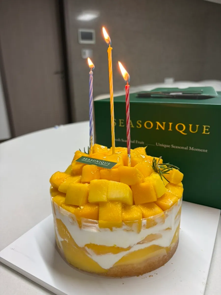 Mango cake with lit candles