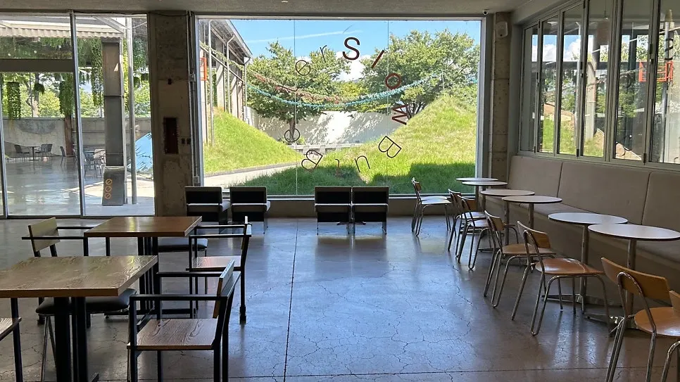 Interior with large windows showing green views