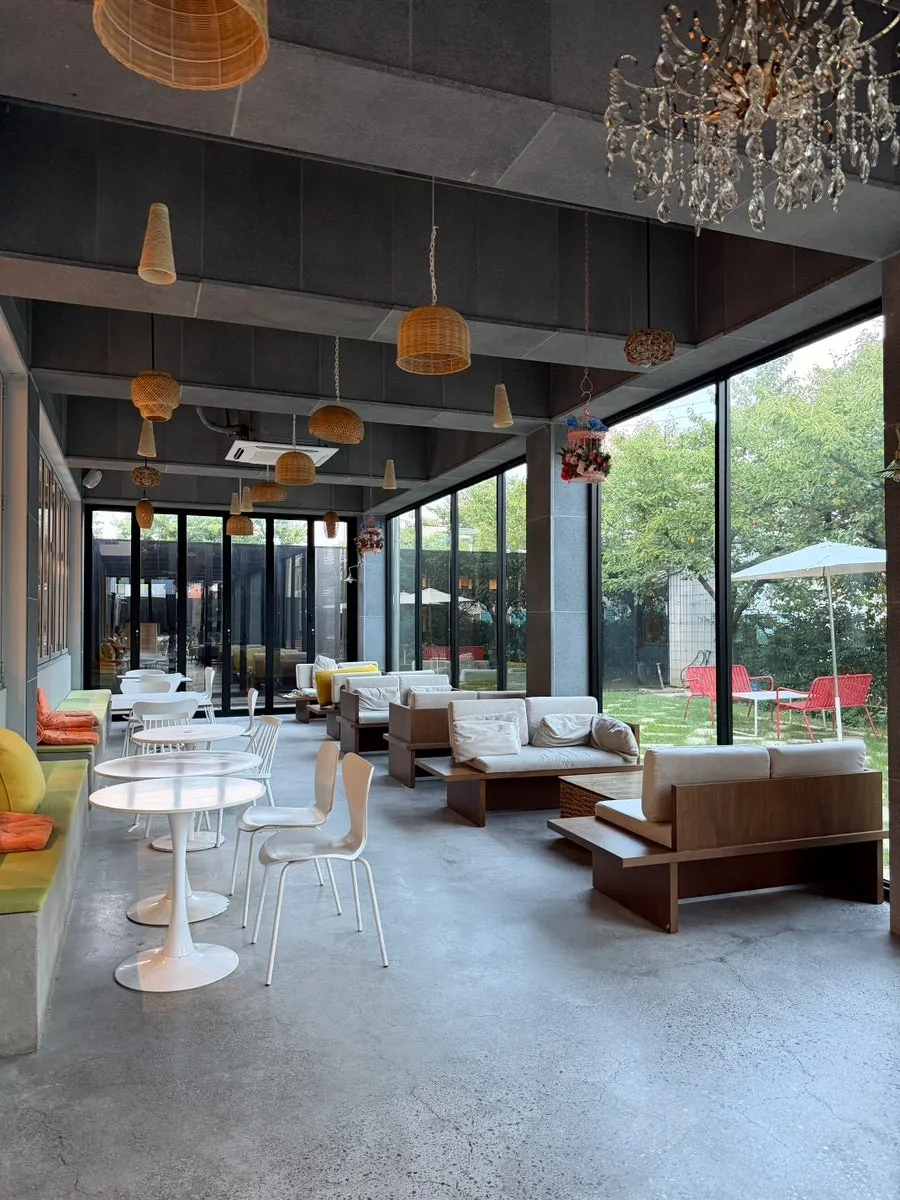 High-ceilinged café interior seating decorated with plants