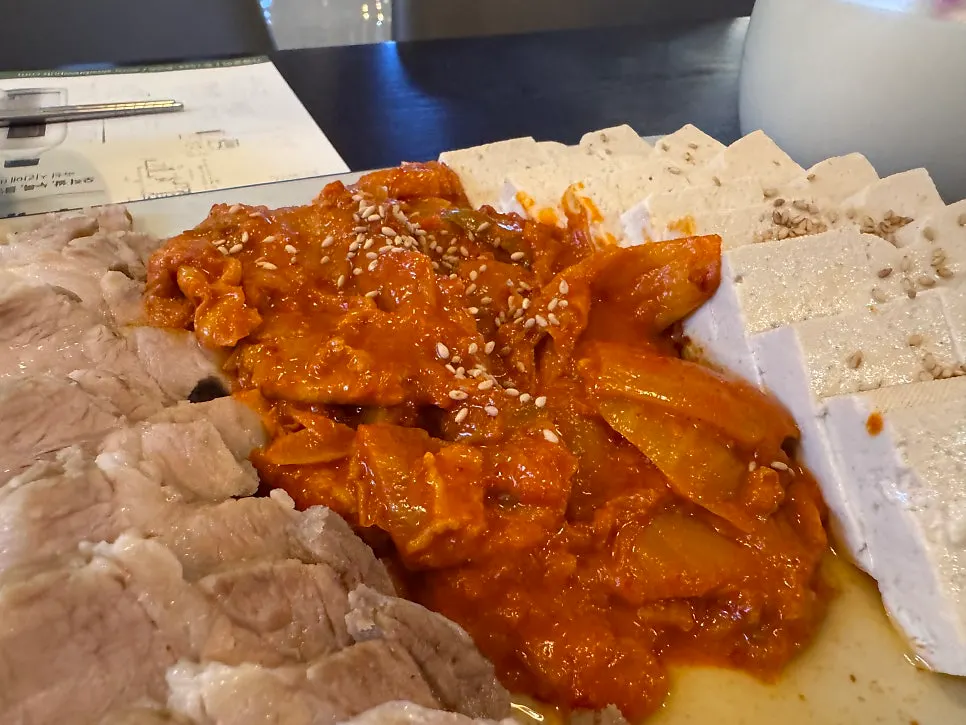두부김치 한판과 막걸리 잔이 놓인 테이블