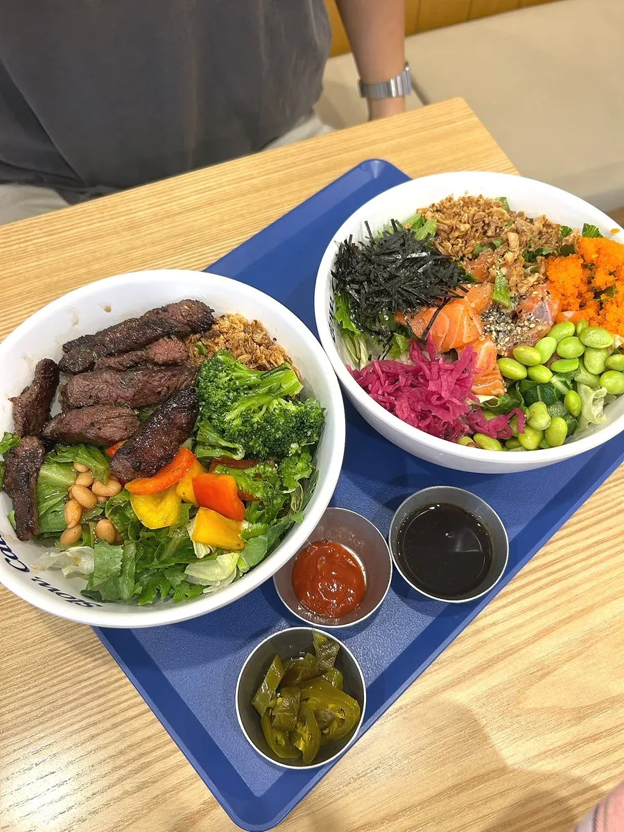 Two poke bowls on brown rice and salad base