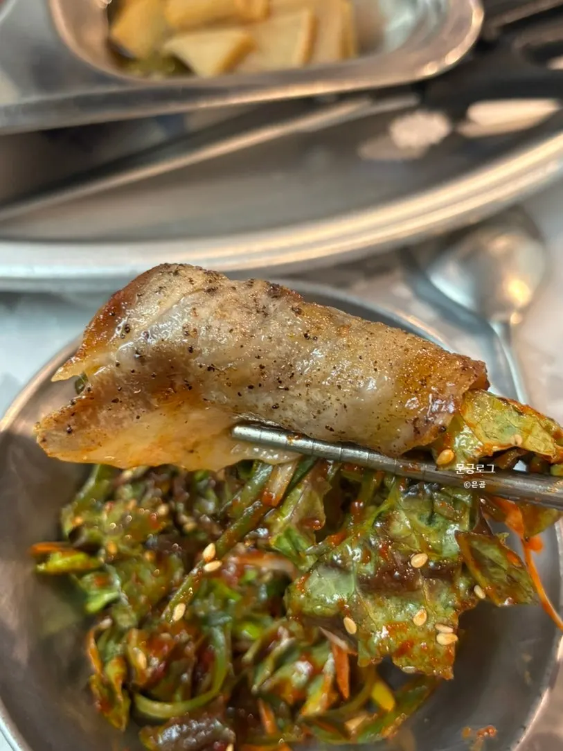 A piece of naengsam topped with scallion salad